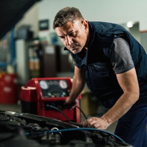 Auto mechanic inspecting under the car hood